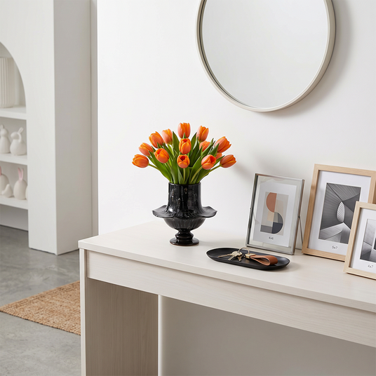 Black flared vase on minimalist white entry table