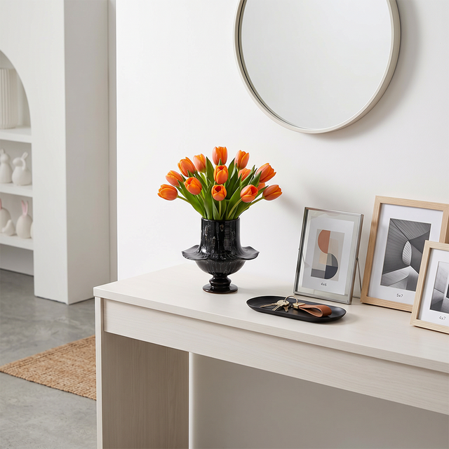 Black flared vase on minimalist white entry table