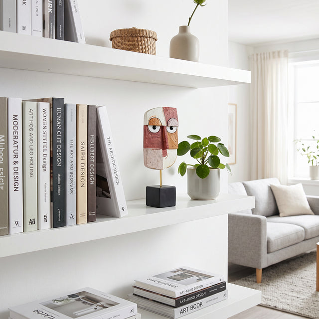 Geometric Face Sculpture On White Shelf