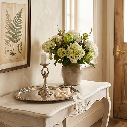 Human figure candleholder on cream entry table