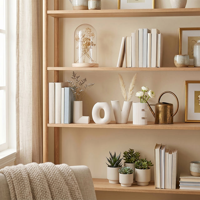LOVE vases on shelf with books and flowers