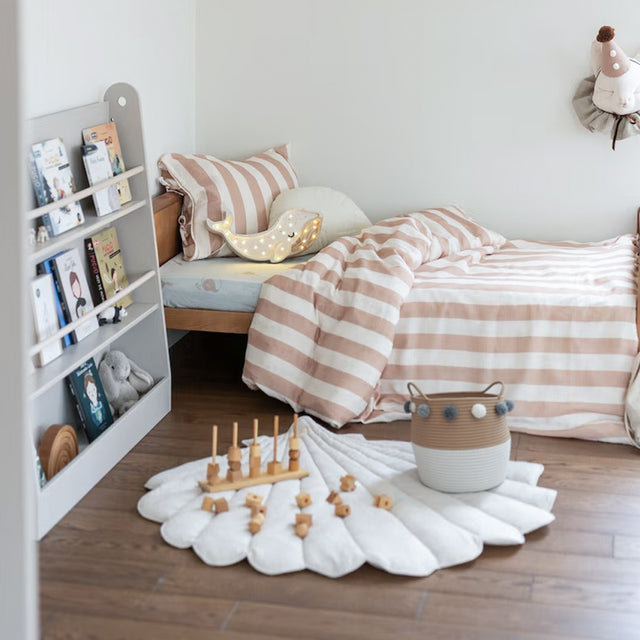 Scandinavian Rope Woven Toy Clothing Storage Basket with Pom Poms on the Floor