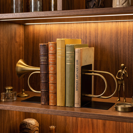 Vintage trumpet bookends on lit walnut bookcase