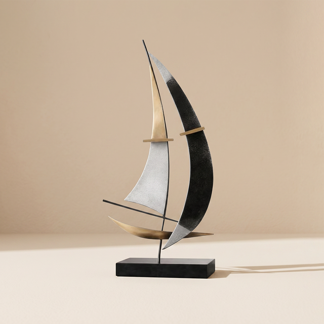 abstract black and gold metal sailboat sculpture