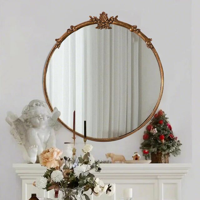 baroque brass round mirror hanging on the wal