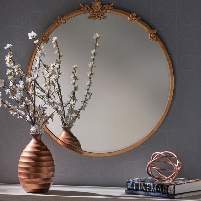 baroque brass round mirror hanging on the wall