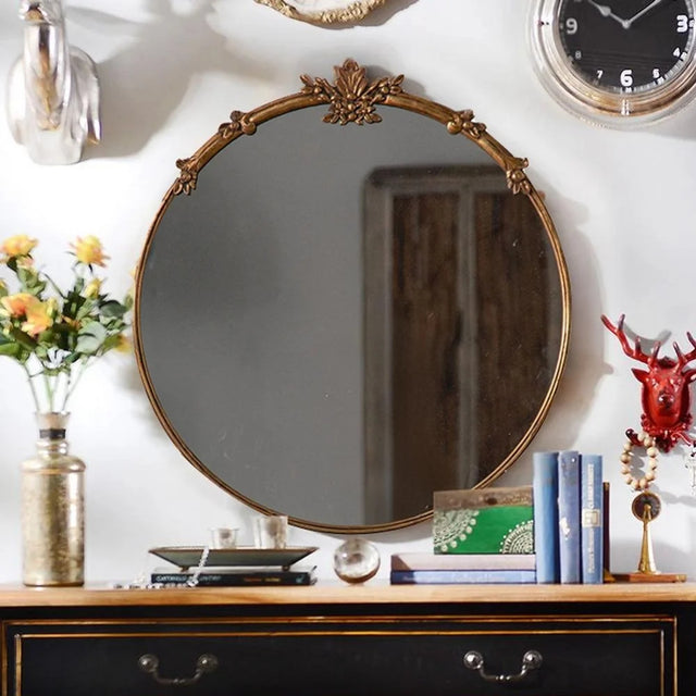 baroque brass round mirror hanging on the wall