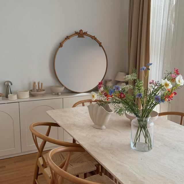 baroque brass round mirror leaning against the wall