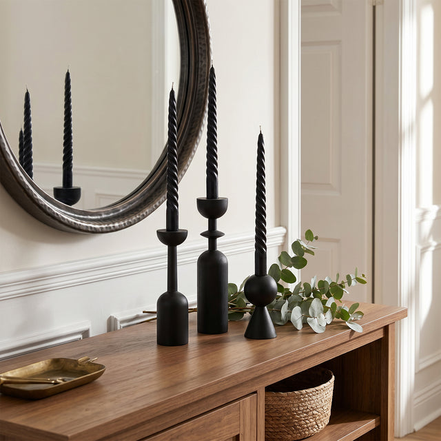 black candle holders on entryway console with mirror