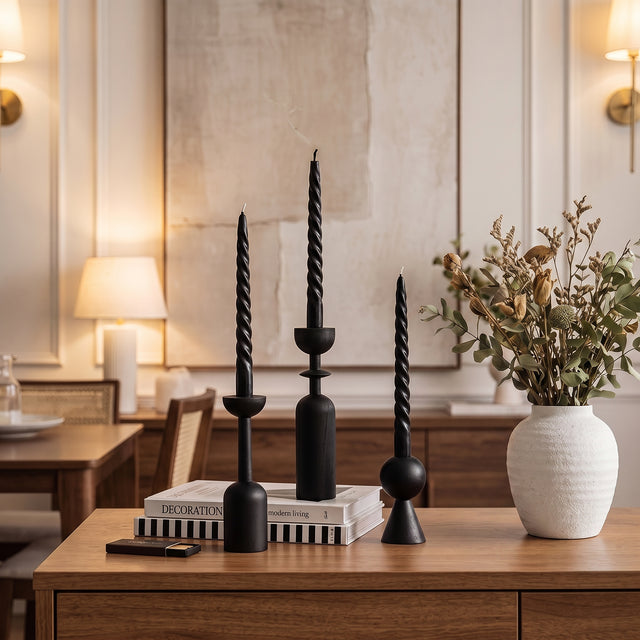 black candle holders on wooden cabinet with books