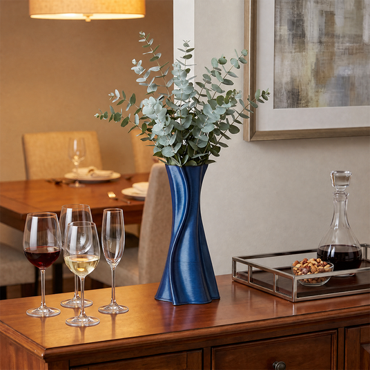 blue twisted vase with eucalyptus on wooden cabinet