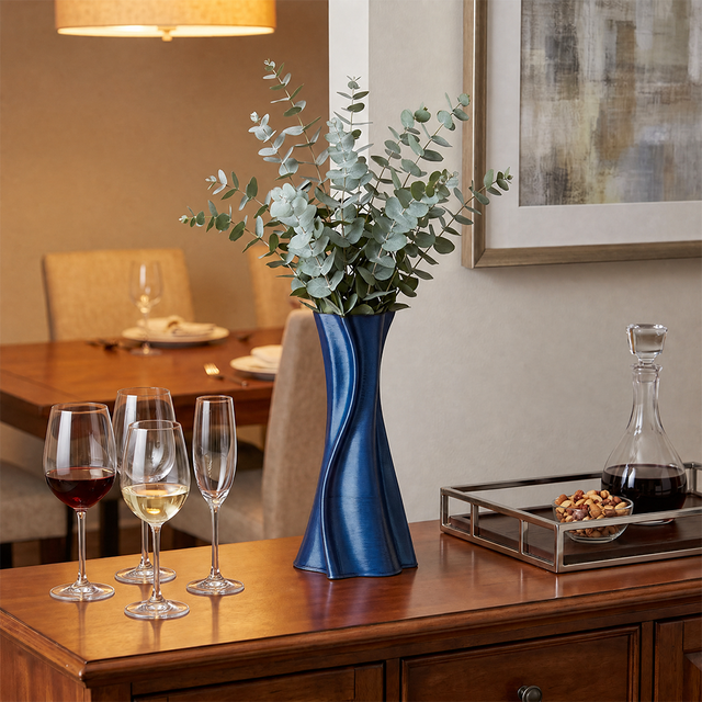 blue twisted vase with eucalyptus on wooden cabinet