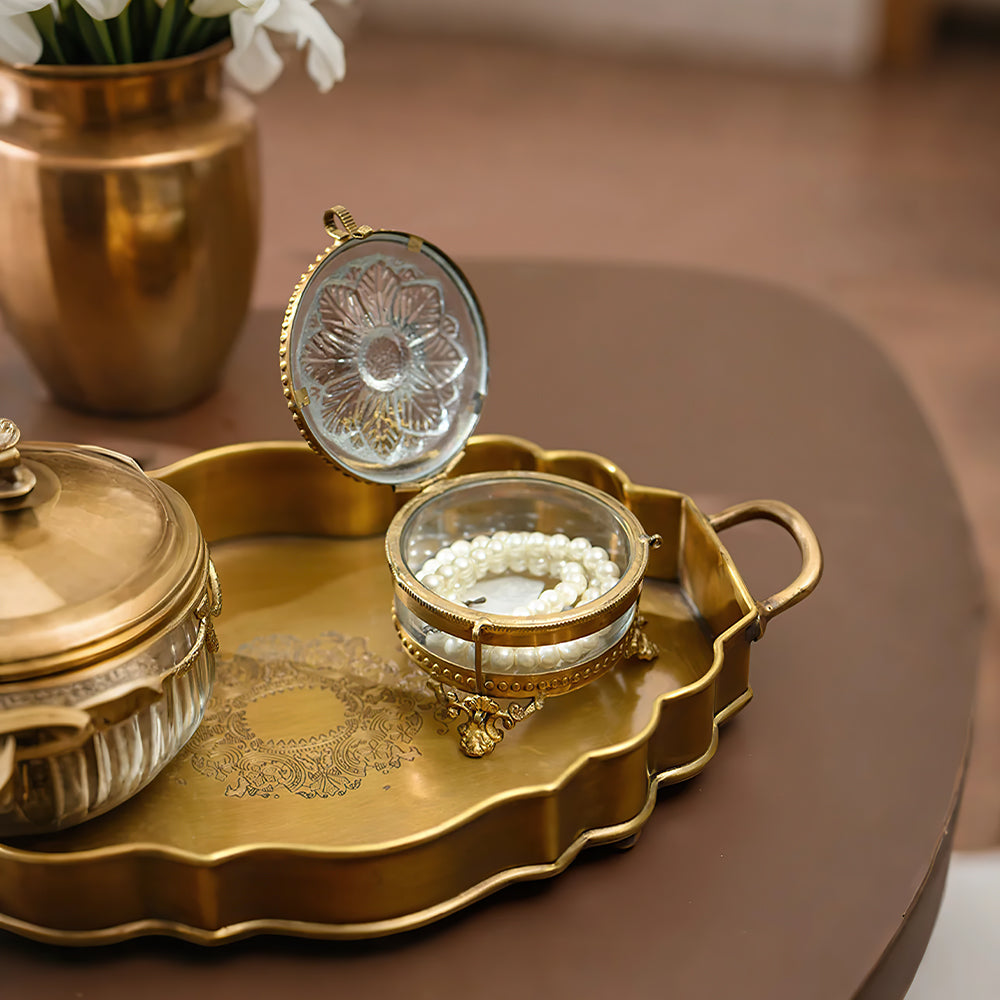 brass and glass carved decorative storage jar jewelry on the table