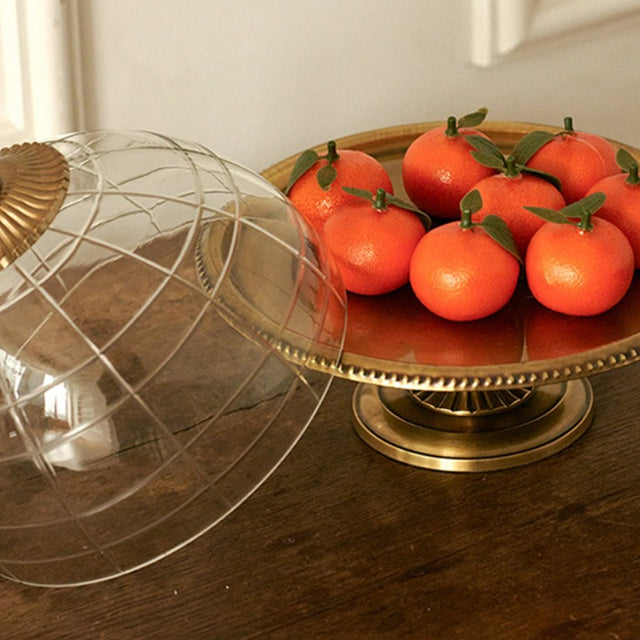 brass cake stand with orange on the table