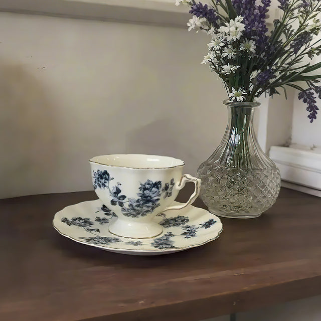 ceramic floral tea set placed beside a glass vase