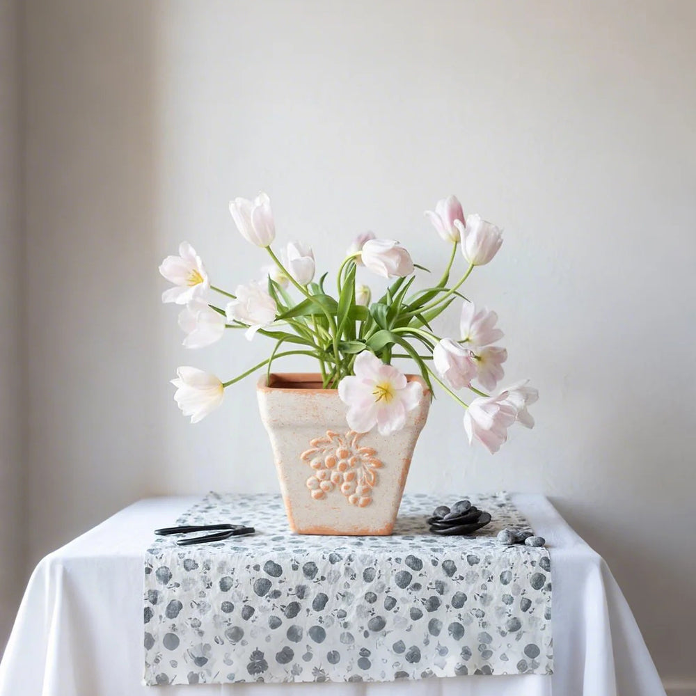 clay vase filled with flowers on the table
