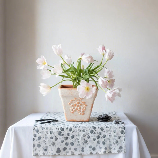 clay vase filled with flowers on the table