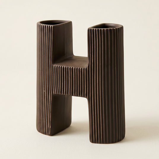 close up of brown ceramic letter h vase