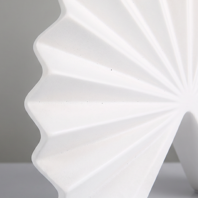 close up of white pleated vase folded lines