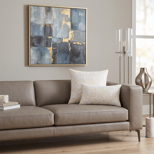 cream embroidered pillows on taupe leather sofa