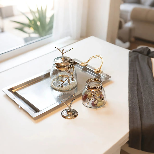 decorative glass brass golden jar with a leaf shaped lid on the table