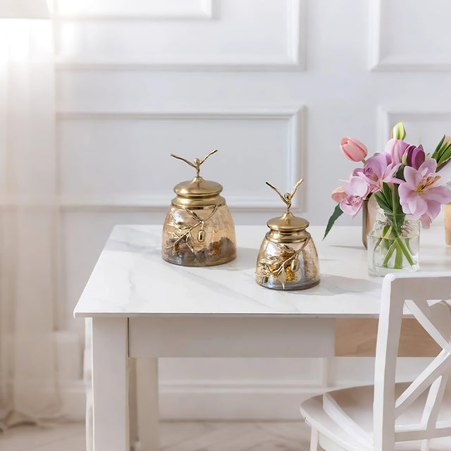 decorative glass brass golden jar with a leaf shaped lid on the table