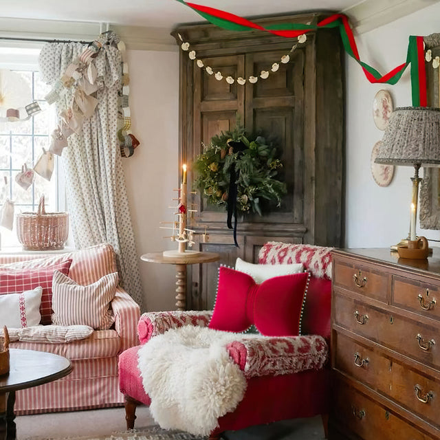 decorative red bow throw pillow on red sofa