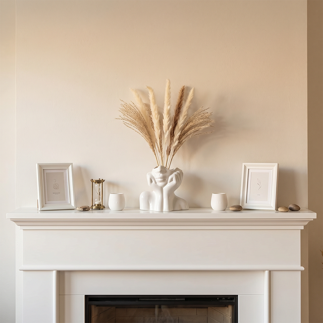 face vase with pampas grass on fireplace mantel