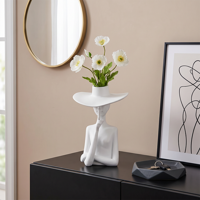 figure vase with flowers on black cabinet
