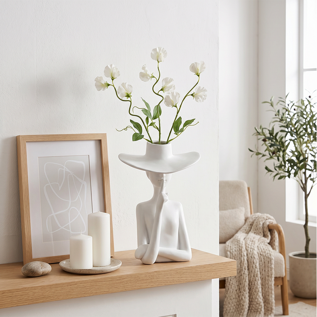 figure vase with white flowers on shelf