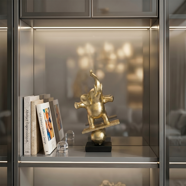 gold elephant sculpture on modern glass shelf