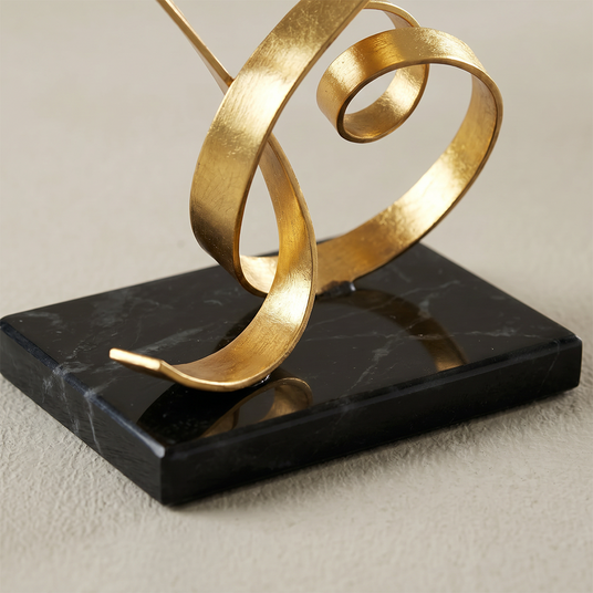 gold love sculpture black marble base close up