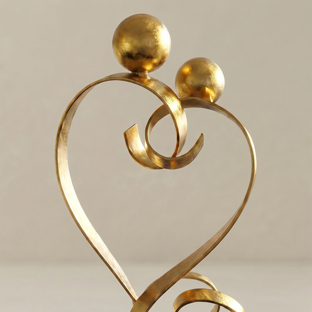 gold love sculpture heads detail close up