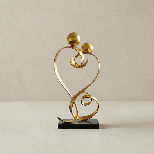 gold love sculpture on black marble base