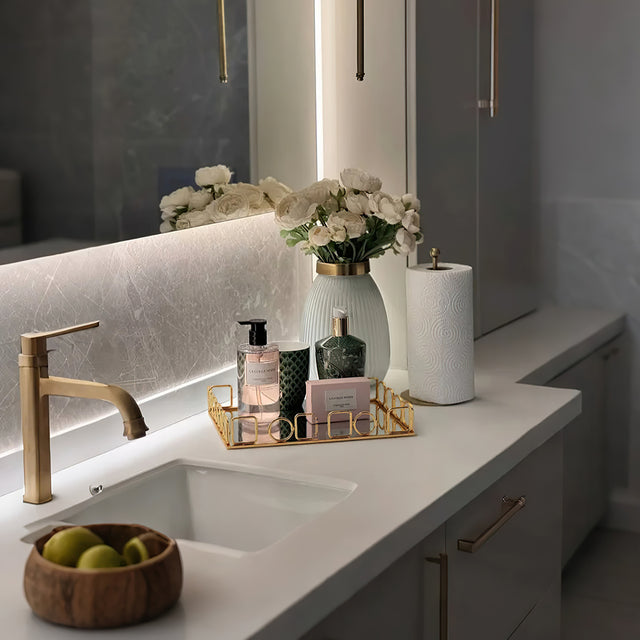 gold metal decorative tray on the sink counter