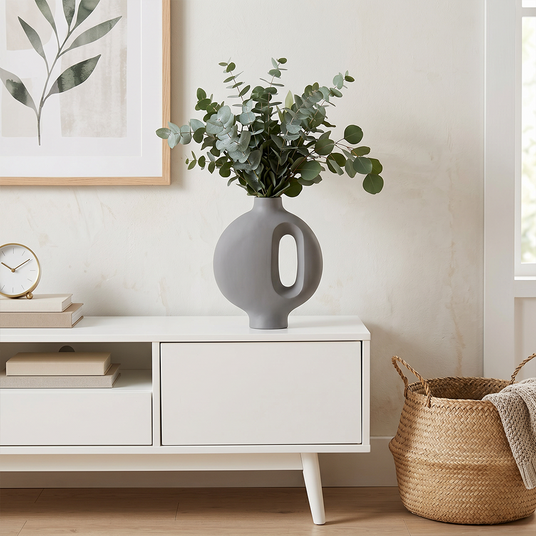 grey vase with eucalyptus on white cabinet