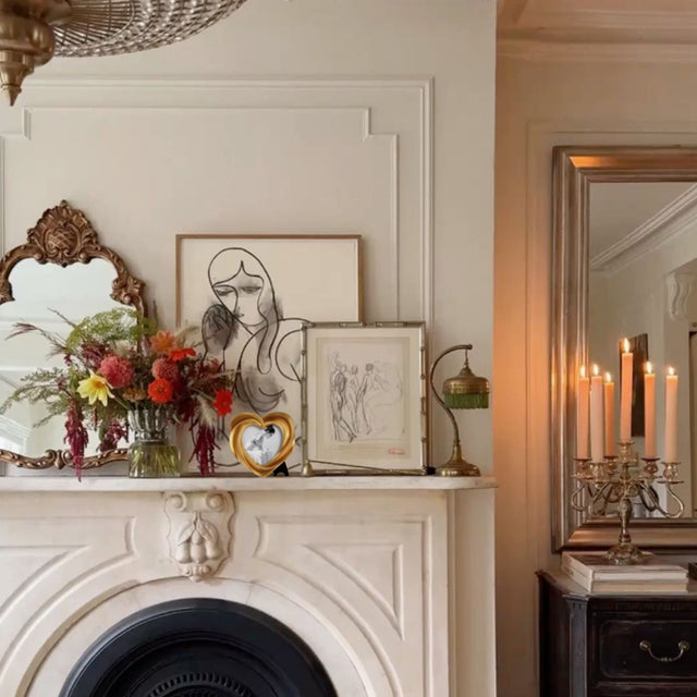 heart-shaped golden decorative picture frame on the fire place