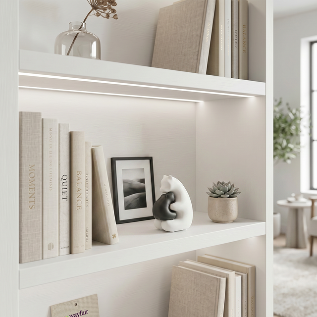 hugging bear figurine on white shelf with books