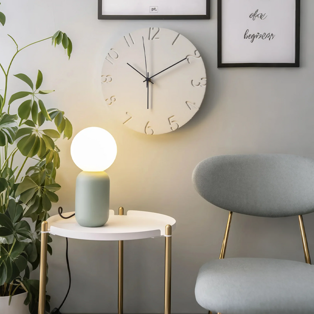 instagram style creative cement wall hanging clock beside the hanging painting