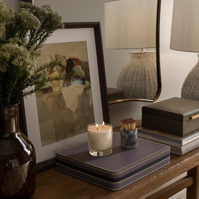 leather jewelry storage box placed underneath photo frame and candles