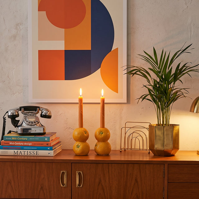 orange candle holders on sideboard