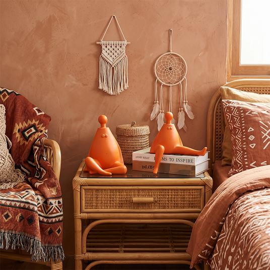 orange figurines on rattan nightstand