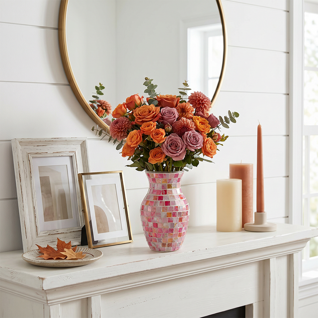 pink mosaic vase with orange flowers on mantel