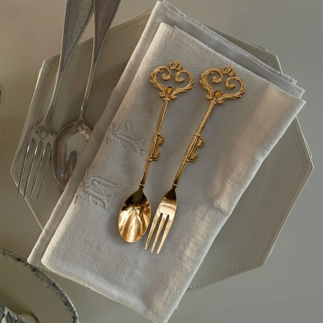 retro stainless steel golden key shaped fork and spoon in the dinner plate