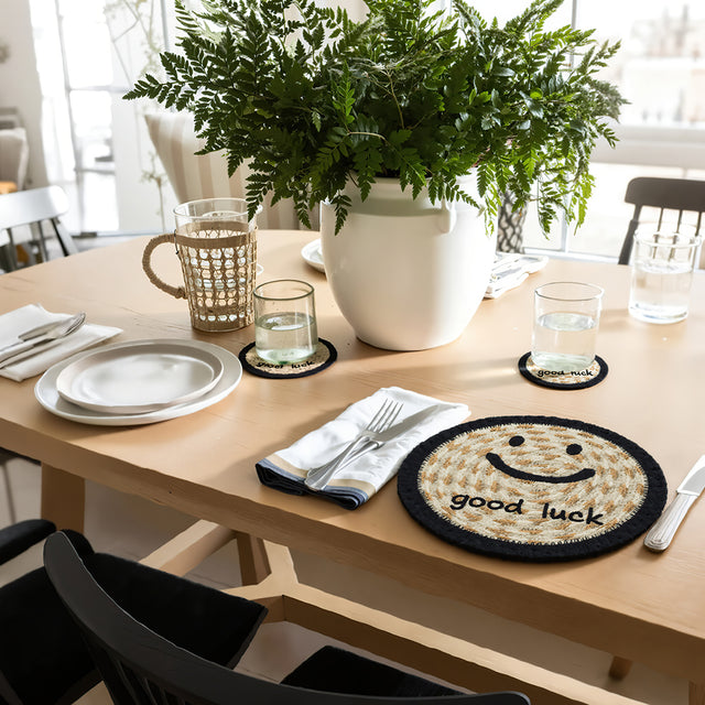 round jute woven smiling face table coaster on the table