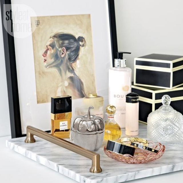 silver pumpkin shaped decorative storage jar on marble tray