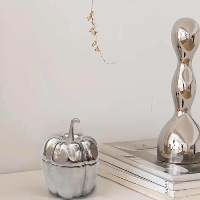 silver pumpkin shaped decorative storage jar on the table