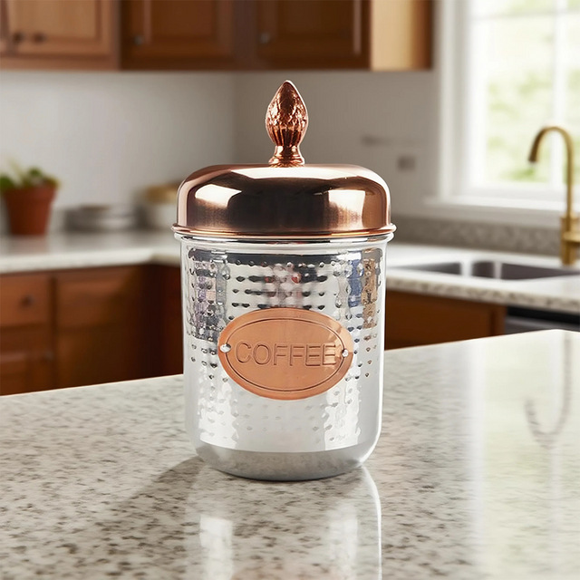 stainless steel sealed coffee storage canister with a pineapple handle on the kitchen counter