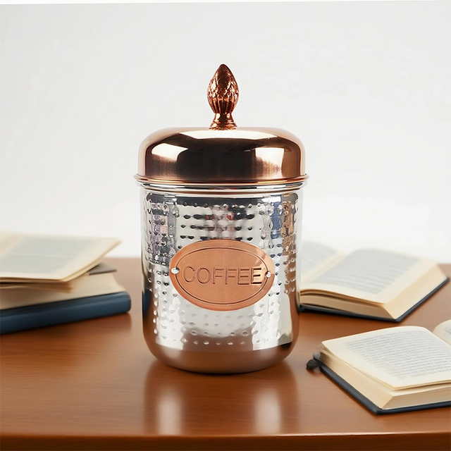 stainless steel sealed coffee storage canister with a pineapple handle on the table