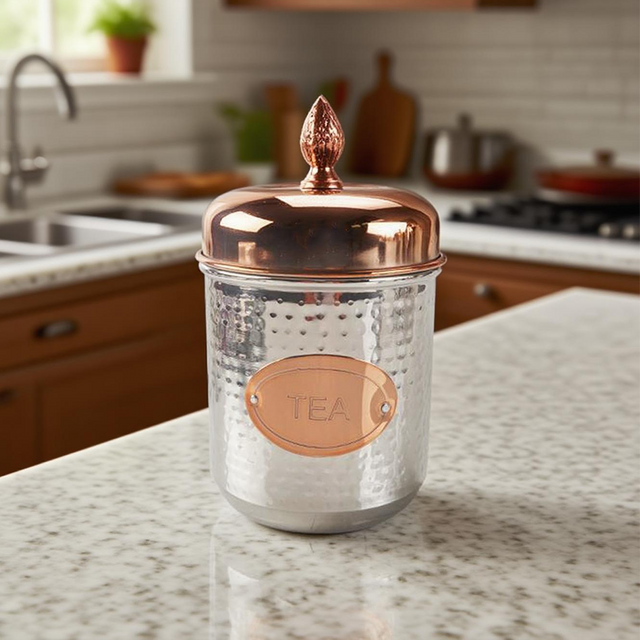 stainless steel sealed tea storage canister with a pineapple handle on the kitchen counter